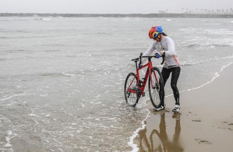 Isabella dips her bike into the Pacific Ocean at the start of her cross-country bike ride Isabella dips her bike into the Pacific Ocean at the start of her cross-country bike ride