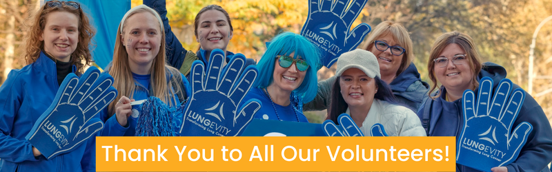 Group of seven volunteers in blue smiling at the camera