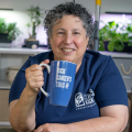 Laurie Seligman holding her KRAS kickers coffee mug