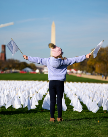 girl surrounded by white flags