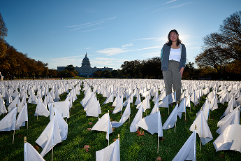 Woman standing in field of flags