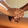 Two people holding hands supportively